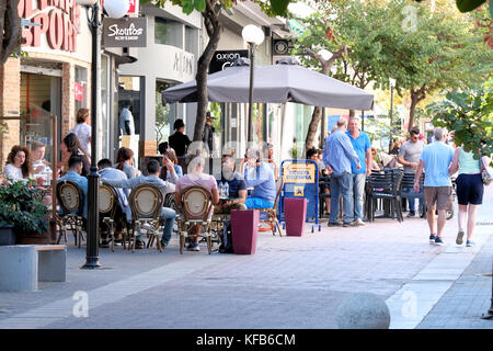 Eine geschäftige Straßenszene, in der sich die Menschen außerhalb der überfüllten Straßen entspannen Bars in Rhodos-Stadt auf den griechischen Inseln Rhodos Stockfoto