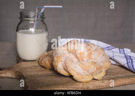 Hausgemachte süße Brötchen und Milch Glas Stockfoto