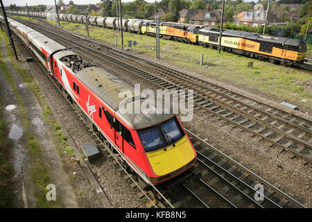 Virgin trainiert die E-Lokomotiven der Baureihe 91 der East Coast, vorbei an den Colas Rail Freight Lokomotiven 70814 und 60095 auf den Anschlussgleisen von Holgate südlich des Bahnhofs York, Großbritannien. Stockfoto