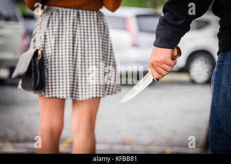 Dieb oder Räuber ist goting zu berauben, die Frau, die durch Messer. Gewalt und roberry Konzept. Stockfoto