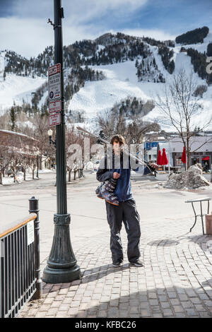 USA, Colorado, Aspen, Portrait eines lokalen Skifahrer in die Innenstadt von Aspen, mit Ajax-Berg in der Ferne Stockfoto