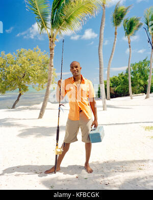 USA, Florida, Porträt eines erwachsenen Mannes auf Strand mit Angelrute und bekämpfen, Islamorada Stockfoto