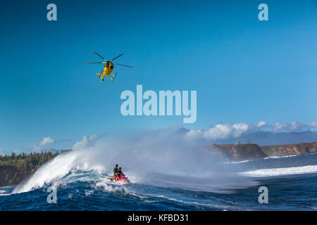 Usa, Hawaii, Maui, Backen, einem schwebenden Hubschrauber über den großen Wellen und Surfer an peahi auf dem northshore Stockfoto