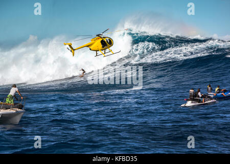 Usa, Hawaii, Maui, Backen, einem schwebenden Hubschrauber über den großen Wellen und Surfer an peahi auf dem northshore Stockfoto