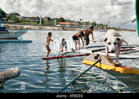 Philippinen, Palawan, Puerto Princesa, Kinder spielen auf Fischerbooten in der Stadt Port Bereich Stockfoto