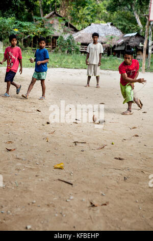 Philippinen, Palawan, Barangay region, Batak Jungen spielen mit ihrer Hand Spielzeug in kalakwasan Dorf Stockfoto