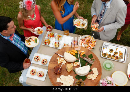 USA, Tennessee, Nashville, Irokesen Steeplechase, Freunde stehen rund um ein Buffet Essen und Trinken Stockfoto