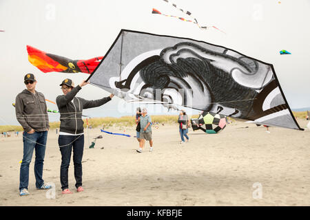 USA, Washington State, Long Beach Halbinsel, internationale Drachenfest, Paar starten eine große, schwarze und weiße im japanischen Stil Kite Stockfoto