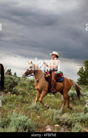 USA, Wyoming, Lager, ein Cowgirl reitet auf einem Pferd durch die Sage-Pinsel, Abara Ranch Stockfoto