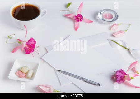 Kreative flach Foto von Arbeitsplatz mit Schreibtisch mit Smartphone, Kaffee, Bleistift, Blumen mit Kopie Raum Hintergrund. Flach Stockfoto