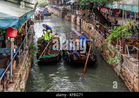 Stock Foto - Touristen in Ruderboote in einem Kanal in einer alten Stadt in China fahren, eine Frau ist Rudern eine der Yacht ist ein Mann der anderen Rudern Stockfoto