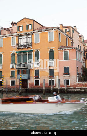 Italien, Venedig. Ein Wassertaxi vergeht vor einem Haus entlang der Grand Canal. Stockfoto