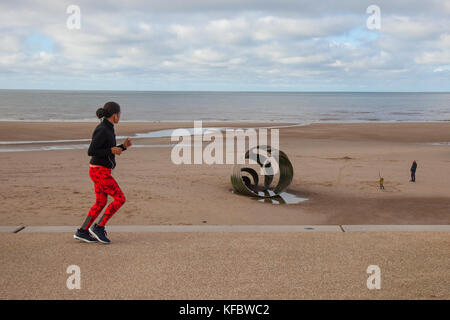 Cleveleys, Lancashire, UK. 27. Oktober, 2017. UK Wetter: Sonnig mit kräftigen Winde an Cleveleys. Das Sands rund um St Mary's Shell ein öffentliches Kunstwerk am nördlichen Ende der neuen Promenade. Es ist ein großes Stück von Kunst im öffentlichen Raum, mit einer Basis, die zu konkreten Stiftungen in der Strand festgesetzt wurde befestigt. Es ist 8 m lang und 4 m hoch und wiegt 16,5 Tonnen, mit Worten aus der Geschichte von das Meer Schlucken geätzt. Credit: MediaWorldImages/Alamy Leben Nachrichten. Stockfoto