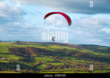 Ein Gleitschirm fliegt über den Onny Tal, von der langen Mynd, Shropshire, Großbritannien gesehen. Stockfoto