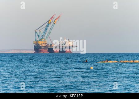 Die Bucht von Larnaca, Zypern. 27. Oktober, 2017. Personen Kajak im Mittelmeer und Blick auf Öl und Gas rigging Plattform in Zypern, Larnaca Bay. Saipem 7000 Verlegung von Krane Credit: RedNumberOne/Alamy Leben Nachrichten angedockt Stockfoto