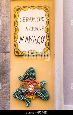 Zeichen und Trinacria Symbol außerhalb ein Geschäft mit Keramik, Taormina, Sizilien, Italien Stockfoto