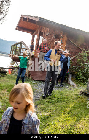 Usa, Alaska, Homer, China poot Bay, die Kachemak Bay, einer der Mitarbeiter das Geigenspiel für andere auf die Kachemak Bay Wilderness Lodge Stockfoto