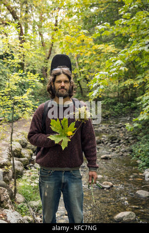USA, Oregon, Ashland, Portrait von Carston Peer in Lithia Park mit Blumen und Blätter, die er gesammelt hat und in einem Kranz gewebt Stockfoto