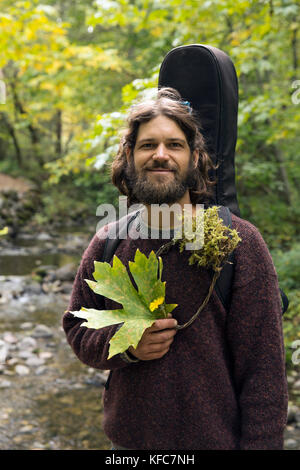 USA, Oregon, Ashland, Portrait von Carston Peer in Lithia Park mit Blumen und Blätter, die er gesammelt hat und in einem Kranz gewebt Stockfoto