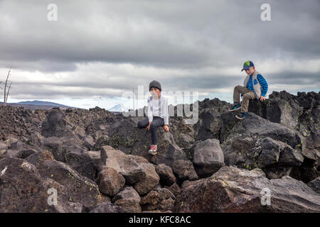 USA, Oregon, Oregon Kaskaden, zwei Jungs auf den Felsen am Dee Wright Observatory spielen in der Mitte eines alten Lavastrom an der Oberseite der McKe Stockfoto