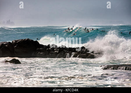 Hawaii, Oahu, North Shore, Surfern im Wasser am Waimea Bay Stockfoto