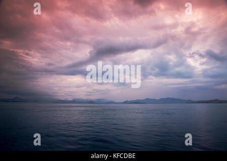 Indonesien, Flores, die Farben der Ende des Tages Weg durch die Wolken über dem Flores Meer vor der Küste von Labuan Bajo Stockfoto