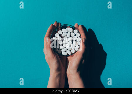 Petrischale mit Pillen in Händen Stockfoto