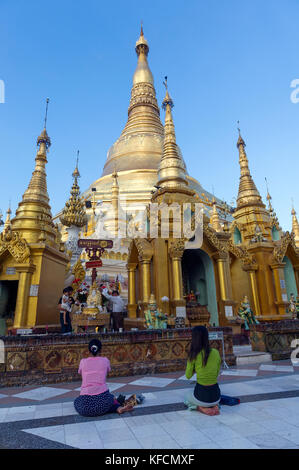 Myanmar (ehemals Burma). Yangon. (Rangun). Frauen, die an der Shwedagon Pagode beten der buddhistische heilige Ort ist das erste religiöse Zentrum Burmas Stockfoto