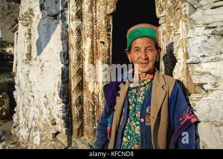 Traditionell gekleidete Ältere kinnauri Frau in natürlicher Umgebung außerhalb einer himalayan Haus in der kinnaur Mountain Region Himachal Pradesh Stockfoto