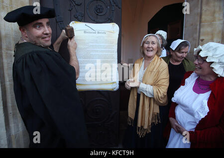 Patrick Rogers und andere Mitglieder der Unitarian Church, St. Stephen's Green, Dublin, während einer Reenactment von Martin Luther Nailing seine historischen Ideen und Meinungen über den Gottesdienst, vor dem 500. Jahrestag der Reformation. Stockfoto