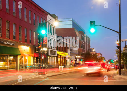 Autos von historischen Gebäuden entlang der Princess Street in der Dämmerung in der Innenstadt von Kingston, Ontario, Kanada fahren. Stockfoto