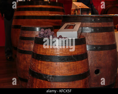 Violett Trauben und weiße Flasche Box auf einem schönen großen Wein Holzfass Stockfoto