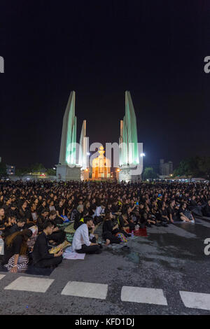 Bangkok, Thailand - 26. Oktober: Nicht identifizierte Trauernde in Schwarz sitzen und die königlichen Aktivitäten für die Verbrennung der Rama 9 Watch, der ehemalige König neben Stockfoto