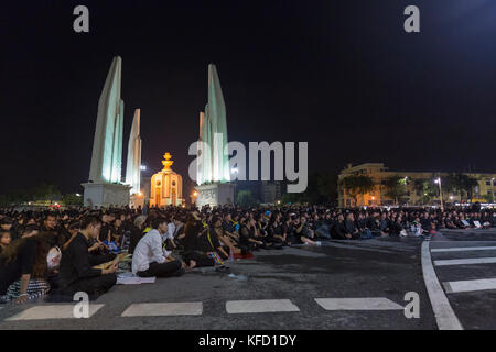 Bangkok, Thailand - 26. Oktober: Nicht identifizierte Trauernde in Schwarz sitzen und die königlichen Aktivitäten für die Verbrennung der Rama 9 Watch, der ehemalige König neben Stockfoto