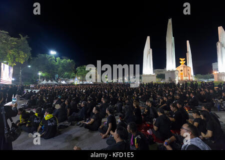 Bangkok, Thailand - 26. Oktober: Nicht identifizierte Trauernde in Schwarz sitzen und die königlichen Aktivitäten für die Verbrennung der Rama 9 Watch, der ehemalige König neben Stockfoto