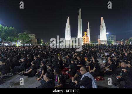 Bangkok, Thailand - 26. Oktober: Nicht identifizierte Trauernde in Schwarz sitzen und die königlichen Aktivitäten für die Verbrennung der Rama 9 Watch, der ehemalige König neben Stockfoto