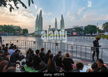 Bangkok, Thailand - 26. Oktober: Nicht identifizierte Personen sitzen neben Demokratie Denkmal am späten Nachmittag für die Verbrennung der Rama 9, der ehemalige König Stockfoto