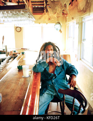 CAYMAN INSELN, Grand Cayman, Porträt der Mann mit Dreadlocks an der Bar sitzen Stockfoto