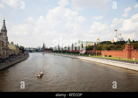 Russland, Moskau. Ein Boot von Touristen auf der Moskwa mit dem Kreml Wand auf der rechten Seite. Stockfoto