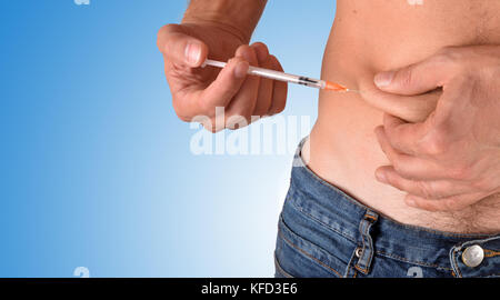 Man Punktion eine Dosis von Insulin auf seinem Bauch schließen oben mit blauen Gradienten Hintergrund. Horizontale Komposition. Ansicht von vorn Stockfoto