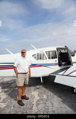 EXUMA, Bahamas. Ein Pilot und sein Flugzeug. Er bringt die Fluggäste von Nassau an den Exuma Islands. Stockfoto