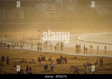 Menschen am Concha Strand am späten Nachmittag Sonnenschein an einem warmen Oktober Tag, San Sebastian, Baskenland, Spanien. Stockfoto