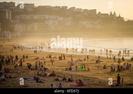 Menschen am Concha Strand am späten Nachmittag Sonnenschein an einem warmen Oktober Tag, San Sebastian, Baskenland, Spanien. Stockfoto