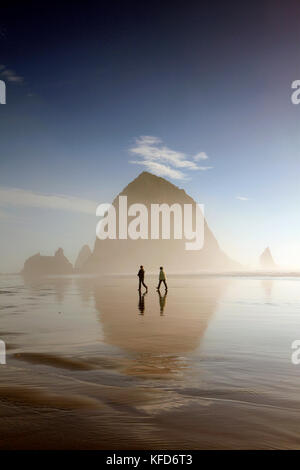 Usa, Oregon, Pacific City, Personen entlang der pazifischen Strand der Stadt mit Haystack Rock in der Ferne Stockfoto