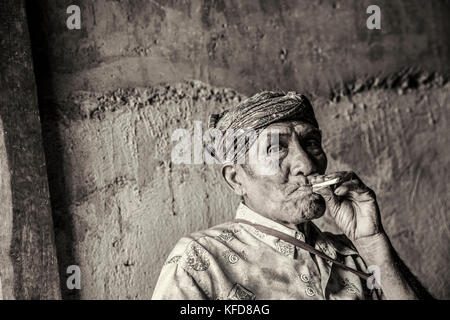 INDONESIEN, Flores, ein älterer Mann Rufus Goa raucht im Dorf Kampung Tutubhada in Rendu Stockfoto