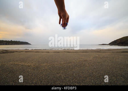 Hand mit einem fidget Spinner am Strand bei Sonnenuntergang. Stockfoto
