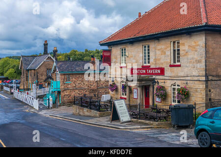 Dunkle Wolken über der Station Taverne und Bahnübergang an der Front Strasse Grosmont North Yorkshire Moors England Stockfoto