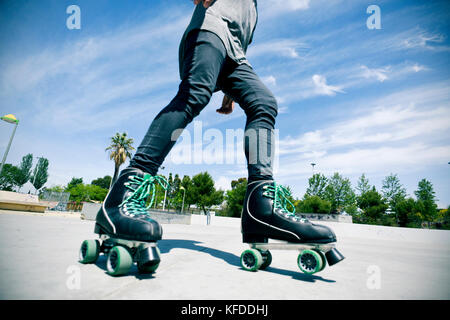 Ein junger kaukasischer Mann Skaten mit Quad Skates in einem freien Skate Park Stockfoto