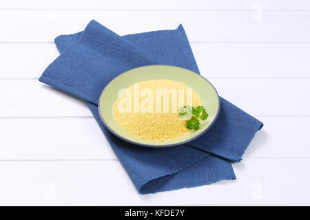 Platte von rohen Couscous auf Blau Platzdeckchen Stockfoto