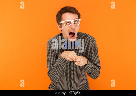 Manager wry dumm und lustige Gesichter. Studio erschossen. Auf orange Hintergrund isoliert Stockfoto